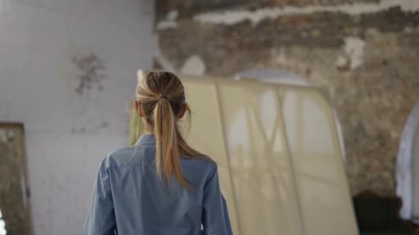 Mujer joven usando delantal para empezar a pintar en el taller — Vídeos de Stock