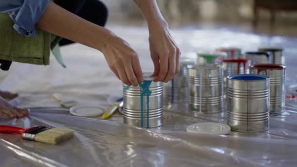 Las manos femeninas en taller de estudio abren diferentes colores de pintura en tarro, preparan suministros — Vídeos de Stock