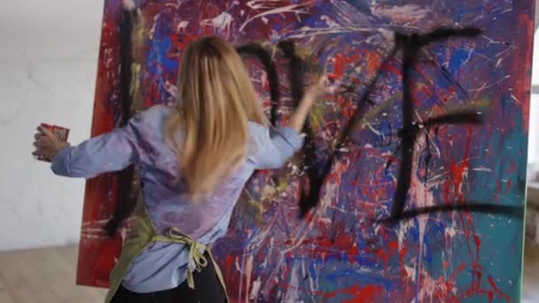 Волнующий художник рисует на холсте эмоционально окуная руки в банку красок и брызги — стоковое видео