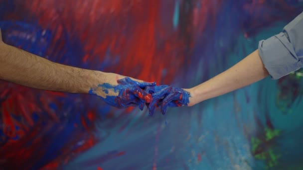 Pasangan tangan dalam cat di depan kanvas berwarna-warni, gerakan menyentuh — Stok Video