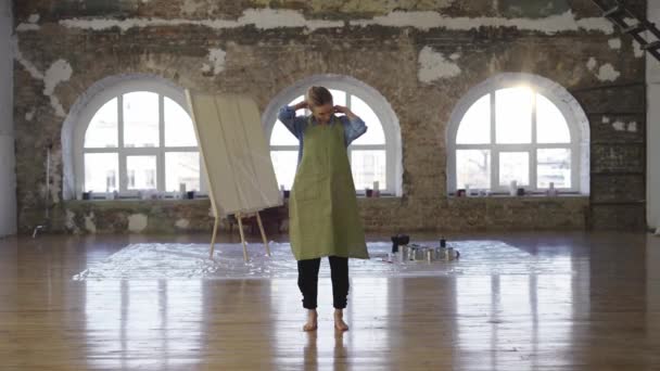 Pełna długość kobieta umieścić na fartuch, aby rozpocząć malowanie w dużym warsztacie — Wideo stockowe