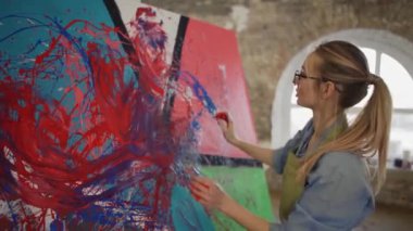 Yenilikçi sanatçı elleriyle büyük renkli tuval, duygusal ve duygusal bir tablo çizer.