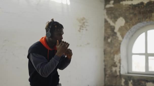 Afro american young male boxer practicing shadow boxing in headphones — Stock Video