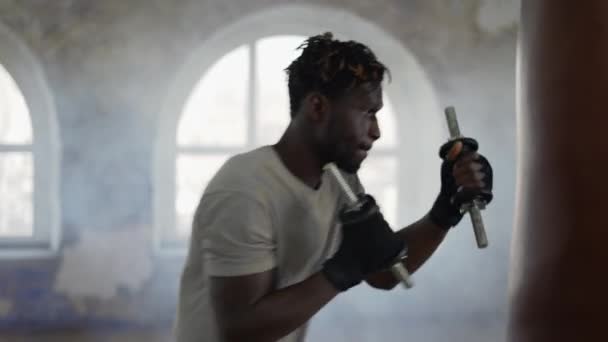 Boxer practicing shadow boxing in foggy sport studio with weights — Stock Video