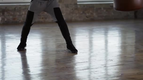 Vue recadrée des jambes d'un boxeur - l'homme s'entraîne au studio de boxe en gants au studio de loft — Video