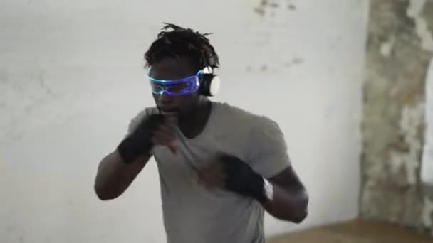 Боксер, практикующий теневой бокс в легкой спортивной студии в стильных очках — стоковое видео