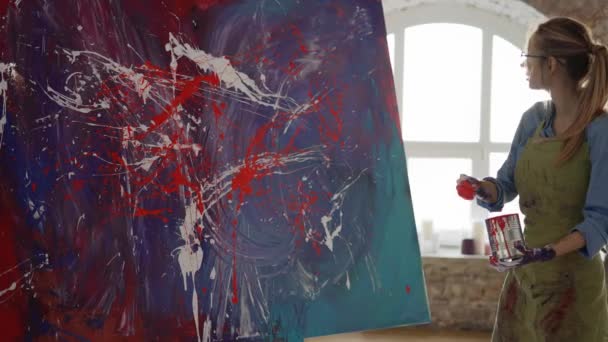 Γυναίκα δημιουργεί αριστούργημα της αφηρημένης ζωγραφικής, ψεκάζει χρώματα σε καμβά — Αρχείο Βίντεο