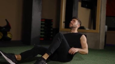 Spor salonundaki erkek, yerden yardım almadan kalkıyor.