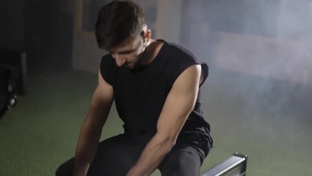 Un sportif barbu s'entraîne dans une salle de gym avec rameur, gros plan — Video