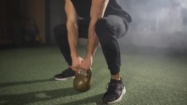 Homme travaillant avec kettlebell, gymnase sombre brumeux — Video