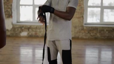 Afro-Amerikan boksör siyah bandajları açıyor.