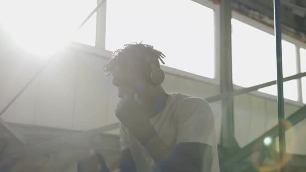 Male boxer practicing shadow boxing around the metal structures indoors, lens flares — Stock Video