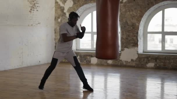 Afro amerikansk boxare slå den tunga väskan i gymmet aktivt — Stockvideo