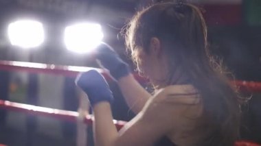 Kadın boksör ağır çekimde bandajla yumruk atıyor.