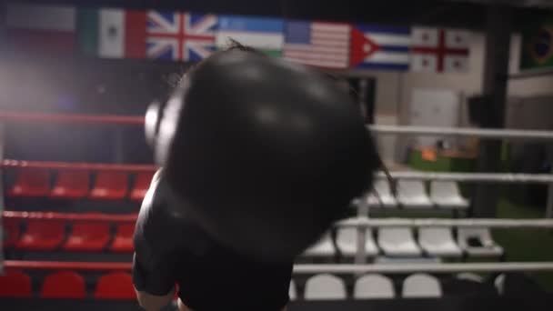 Female boxer punching camera, shadow boxing during workout in dark gym — Stock Video