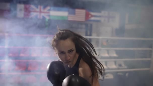 Cámara de boxeo femenina durante el entrenamiento, boxeo de sombras durante el entrenamiento en el gimnasio oscuro — Vídeos de Stock