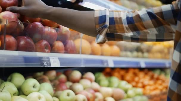 Onherkenbare Afro-Amerikaanse man die in de supermarkt voor appels kiest — Stockvideo