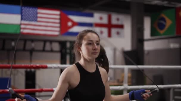 Jovem boxeador feminino com as mãos embrulhadas em bandagem pulando no salto — Vídeo de Stock