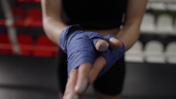 Donna che spolvera polvere sulle mani avvolta in nastri da boxe sul ring — Video Stock