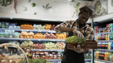 Süpermarkette yeşillik düzenleyen Afrikalı Amerikalı işçi.