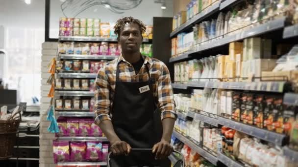 Портрет счастливого продавца в супермаркете с корзиной — стоковое видео