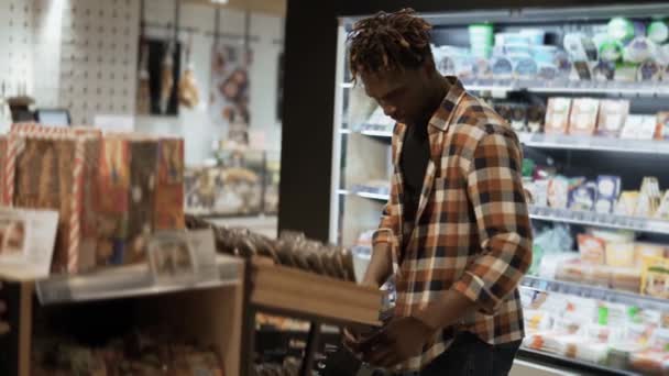 Hombre cliente elige smth en la tienda de comestibles de la estantería — Vídeos de Stock