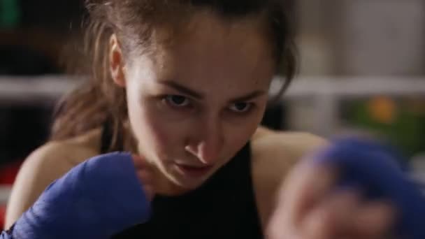 Kvinna boxare utför aktiv stansning i bandage, närbild — Stockvideo