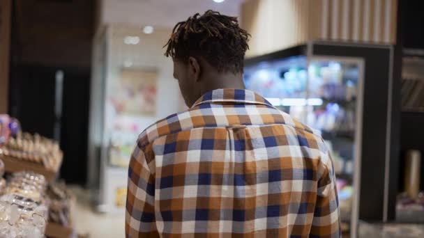 Ο άνθρωπος σπρώχνει τρόλεϊ κατά μήκος σούπερ μάρκετ στο κατάστημα, πίσω όψη — Αρχείο Βίντεο