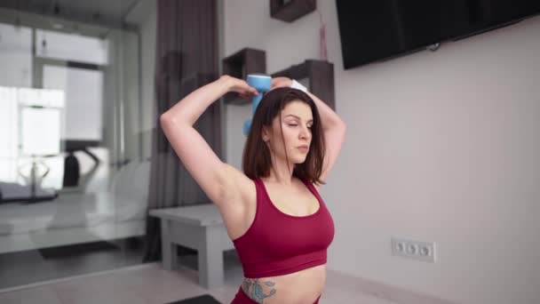 Sportig tjej som tränar med hantlar hemma, framifrån — Stockvideo