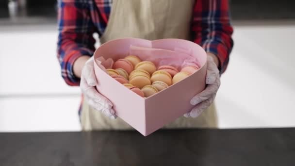 Confiseur dans un tablier contenant des biscuits macarons à la cuisine — Video