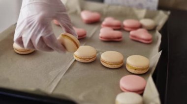 Dişi eller doldurulmuş kurabiyeleri tepsiye koyuyor.