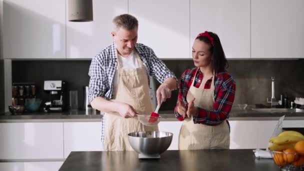 Pár prosévání mouky, aby chleba a pekařství v kuchyni — Stock video