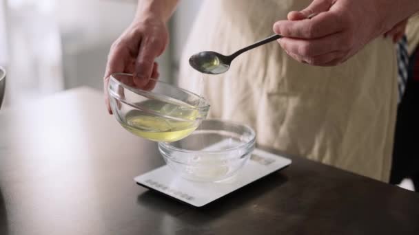 Człowiek poring białka jaj i zmierzyć go w skali kuchennej — Wideo stockowe