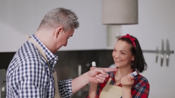 Pareja alegre cocinando junto con diversión y sonriendo — Vídeos de Stock