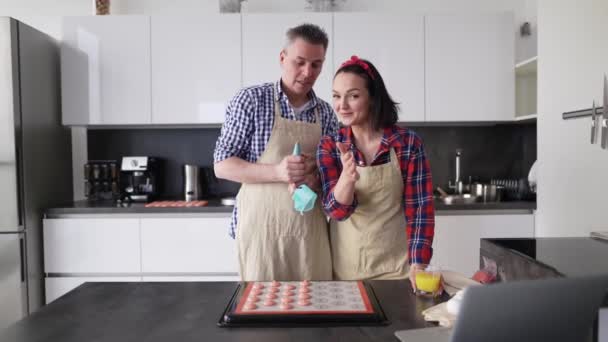 Пара на кухне делает макароны дома, разговаривает на камеру — стоковое видео