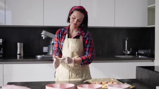 Mujer poniéndose guantes culinarios en la cocina — Vídeos de Stock