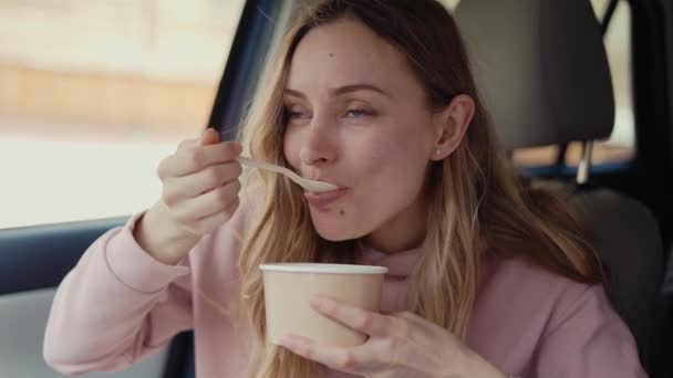 Mujer teniendo su comida dentro del coche estacionado, lento mo — Vídeos de Stock