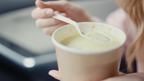 Femme mangeant de la soupe à la crème dans la voiture garée — Video