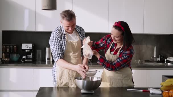 Porträtt av ett par sålla mjöl för att göra bröd i köket — Stockvideo