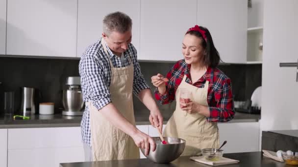 Europäisches Paar kocht zusammen mit Spaß, fügt Geschmack hinzu — Stockvideo