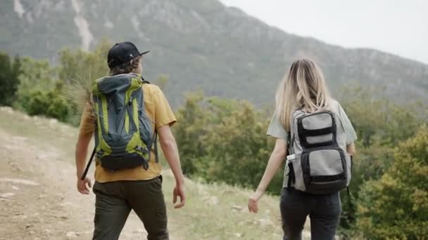 Šťastný pár Backpackers turistiky v kopcích, objevování nových míst — Stock video