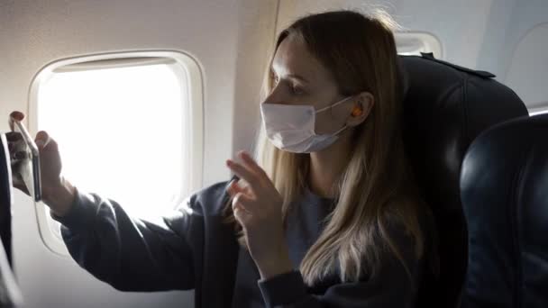 Jovem mulher usando máscara facial, levando selfie a bordo — Vídeo de Stock