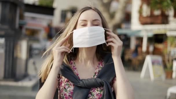 Blondýny žena uvedení na lékařské masky na crowdy ulici — Stock video