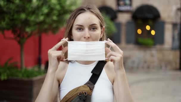 Kobieta zakładająca maskę medyczną dla ochrony koronawirusów na zewnątrz, widok z przodu — Wideo stockowe