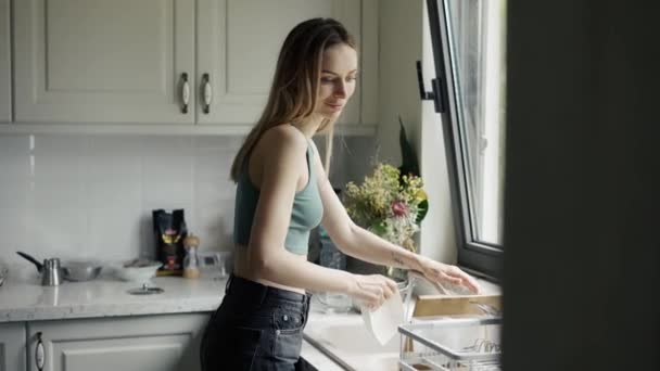 Woman washing dishes under running water in sink at modern kitchen — Stock Video