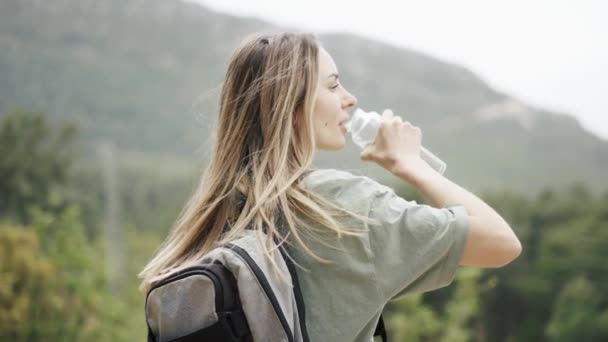 Una donna beve acqua da una bottiglia durante le escursioni — Video Stock