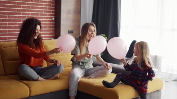 Mère et sa sœur jouent avec des ballons avec une petite fille blonde — Video