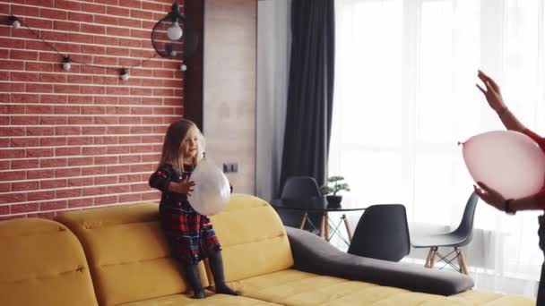 Atraente jovem mãe e sua encantadora filha brincando junto com balões rosa — Vídeo de Stock