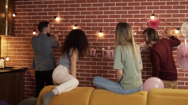 Amigos preparando fiesta en el interior, decorando la sala de estar — Vídeos de Stock