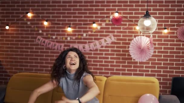 Щаслива молода жінка святкує святкову вечірку на день народження, граючи з повітряною кулею — стокове відео